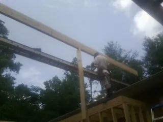 Carpenter setting a ridge beam over a new addition frame — Ice Dam Removal by Roofing Brothers in Penn Laird