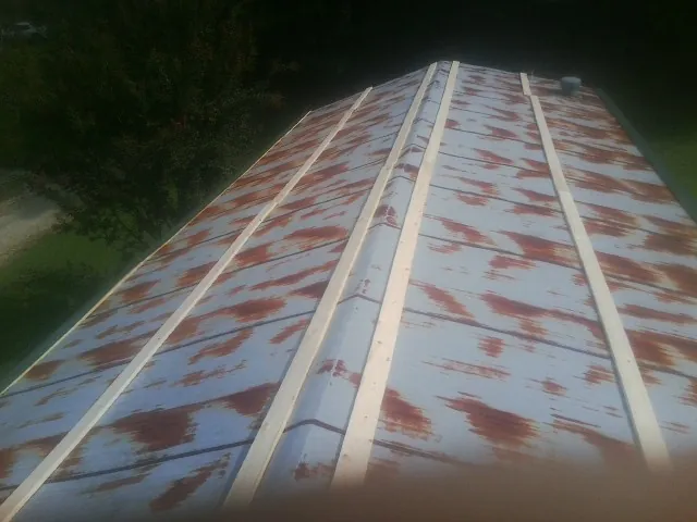 Rusted metal roof panels with new wood purlins before replacement — Storm Damage Roof Repair in Penn Laird by Roofing Brothers
