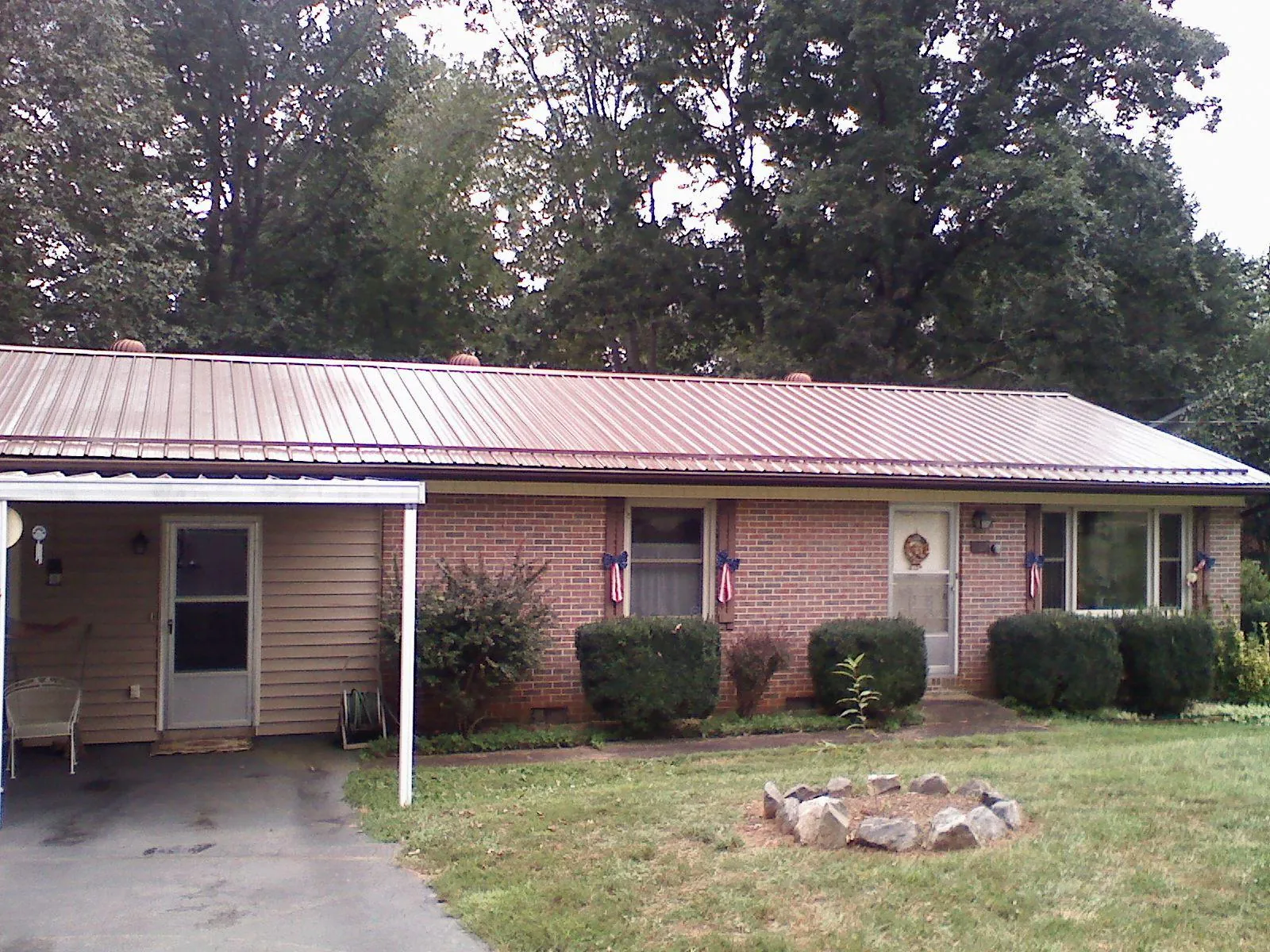 Bronze metal roof and carport on a brick ranch home — Roof Repair work by our crew in Penn Laird